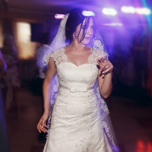 happy gorgeous bride dancing and having fun at wedding party in restaurant reception. funny excited moment of emotional bride and dance. space for text